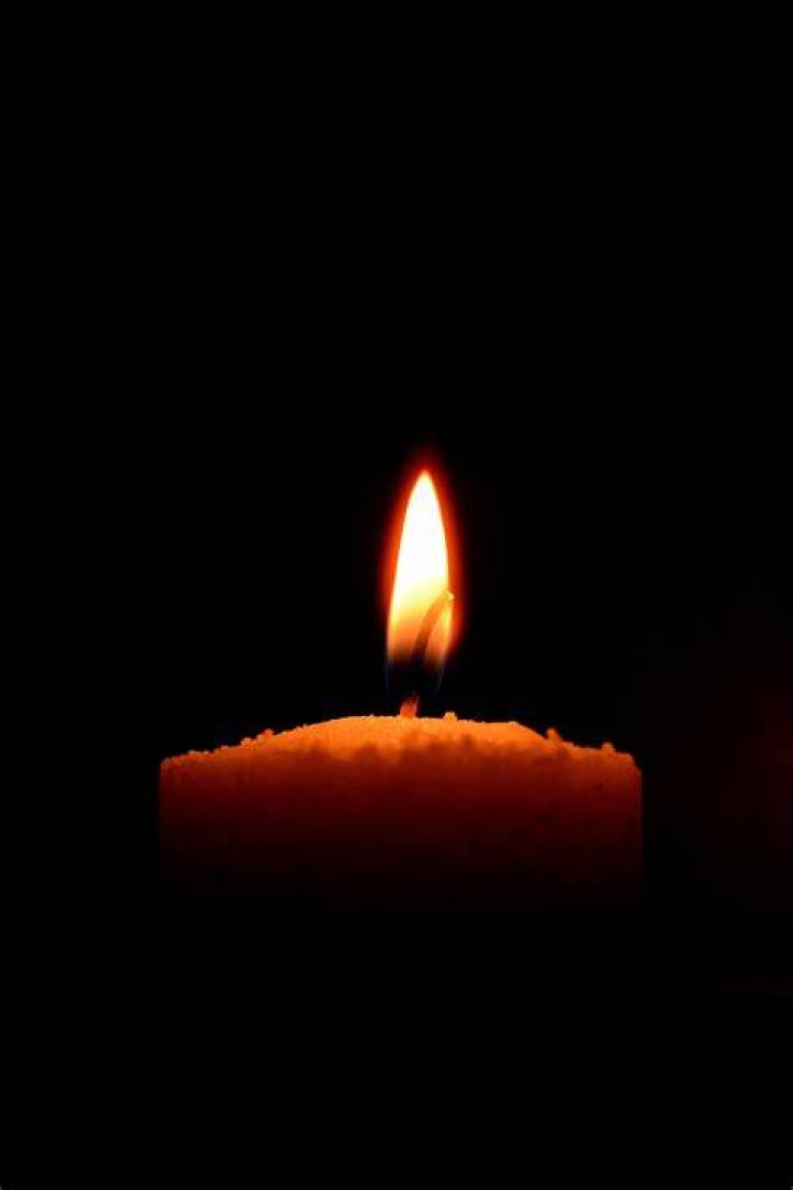 Burning candle on black background, mourning symbol, mourn grief