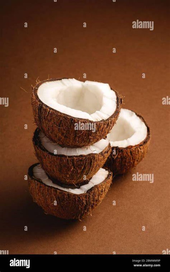 Coconut Fruits Stacked On Brown Wooden Surface · Free Stock Photo